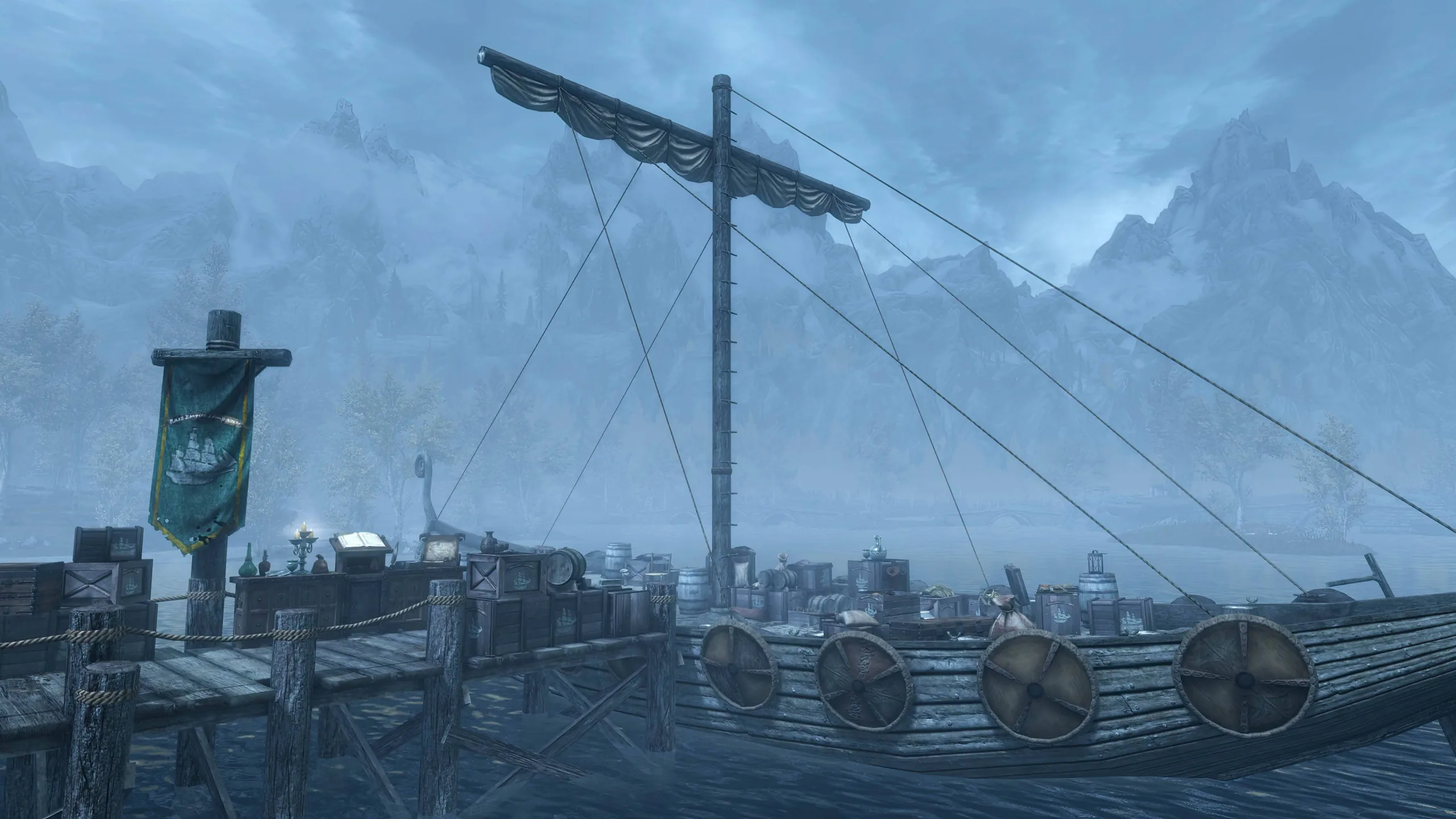 A fully loaded merchant vessel docked at a pier with the towering mountains of Skyrim in the background.